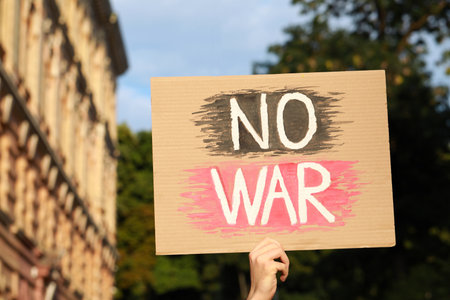 Woman holding poster with words No War outdoorsの写真素材