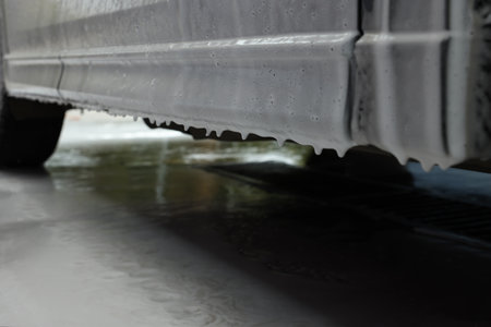 Auto with cleaning foam at car wash, closeup