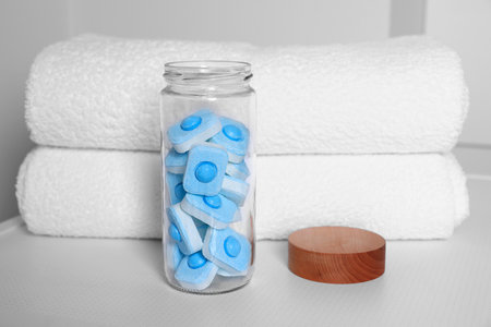 Glass jar with water softener tablets on washing machine in bathroomの写真素材