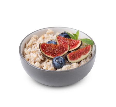 Bowl of oatmeal with blueberries, mint and fig pieces isolated on whiteの写真素材