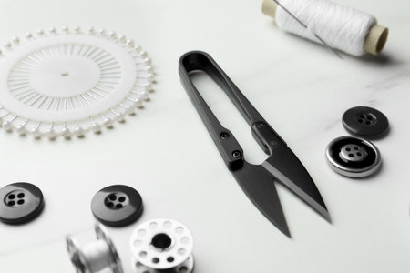 Threads and other sewing supplies on white marble table, closeupの写真素材