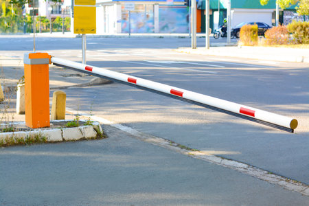 Closed boom barrier near road on autumn day outdoors