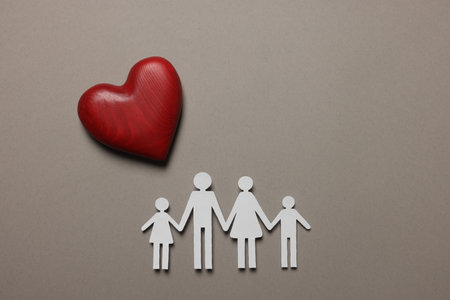 Paper family figures and red wooden heart on light gray background, flat lay. insurance conceptの写真素材
