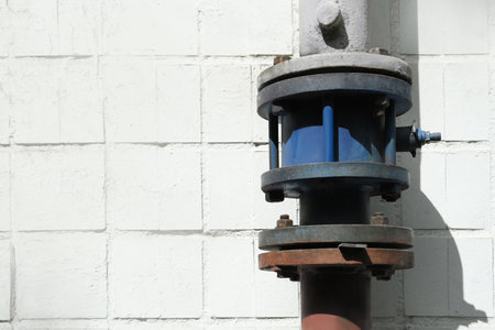 Gas pipe near white brick wall outdoors, space for text