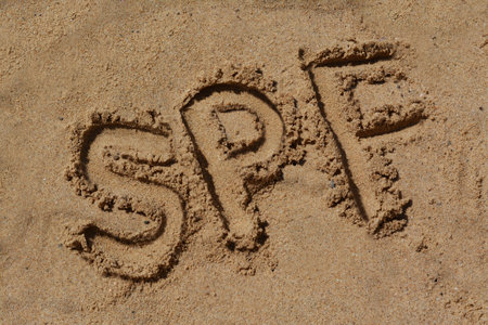 Abbreviation SPF written on sand at beach, above viewの写真素材
