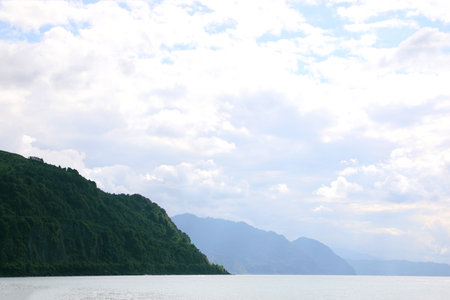 Picturesque view of beautiful sea and mountains under sky with clouds