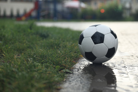 Wet leather soccer ball on street, space for textの写真素材