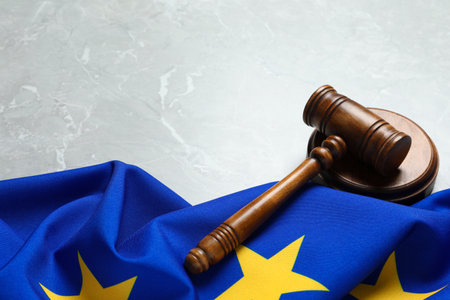 Judge's gavel and flag of European Union on light gray marble table. Space for textの写真素材