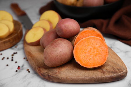 Different types of fresh potatoes on wooden boardの写真素材