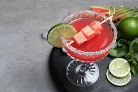 Cocktail glass of delicious fresh watermelon juice, lime and mint on gray table. Space for textの写真素材