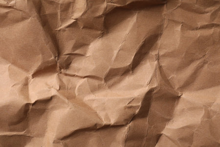 Crumpled kraft paper sheet as background, top view