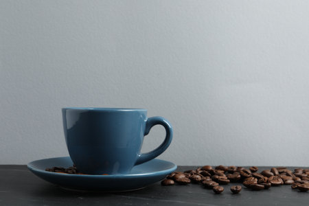 Cup of aromatic coffee and beans on gray table. Space for textの写真素材