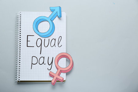 Equal pay. Open notebook and gender symbols on light gray background, top view with space for text