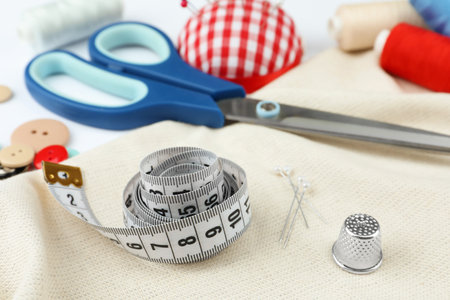 Various sewing accessories on white background, closeup
