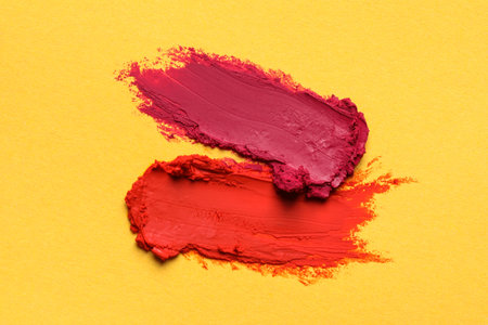 Smears of bright lipsticks on yellow background, top viewの写真素材