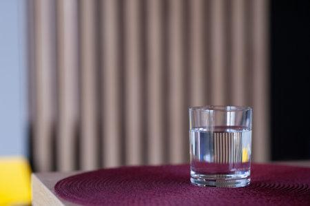 Glass of water on wooden table against blurred background. Space for textの写真素材