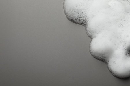 Fluffy soap foam on gray background, top view. Space for textの写真素材