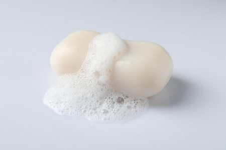 Soap with fluffy foam on white backgroundの写真素材