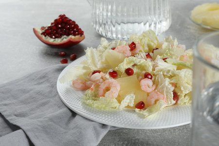 Delicious salad with Chinese cabbage, shrimps and pineapple served on gray tableの写真素材
