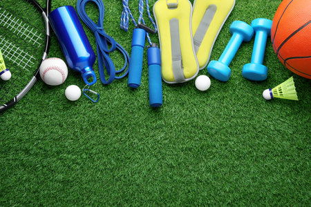 Set of different colorful sports equipment on green grass, flat lay. Space for textの写真素材