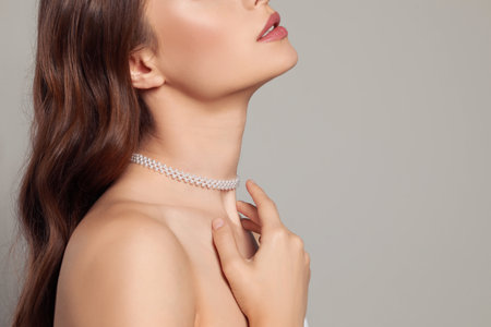 Young woman wearing elegant pearl necklace on gray background, closeup. Space for textの写真素材