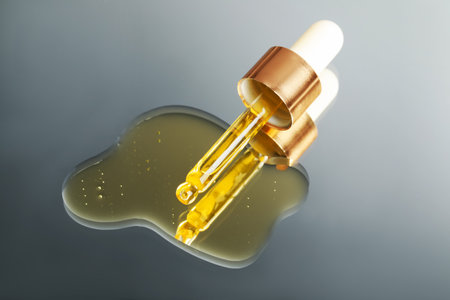 Yellow serum with pipette on mirror, closeupの写真素材