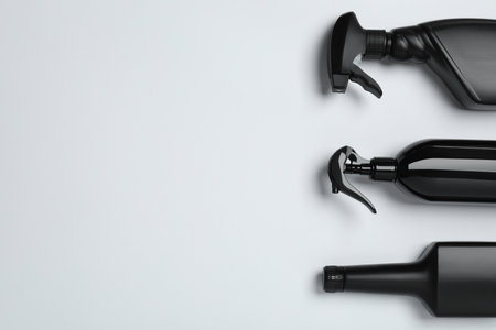 Black bottles on white background, flat lay. Space for textの写真素材