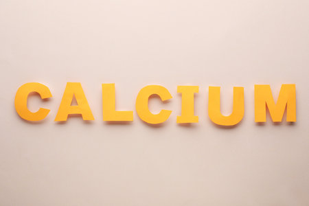 Word Calcium made of orange letters on beige background, flat layの写真素材