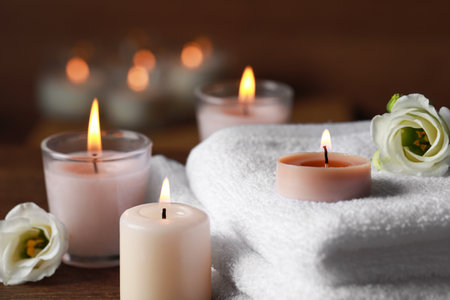 Beautiful spa composition with burning candles and flowers on wooden table, closeupの写真素材