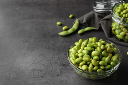 Bowl of delicious edamame beans on gray table, space for textの写真素材