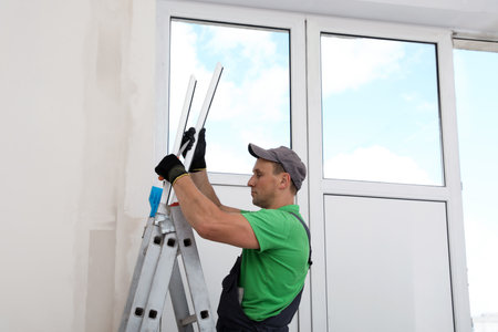Worker with materials for window installation indoorsの写真素材