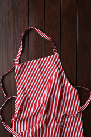 Striped apron on wooden table, top viewの写真素材
