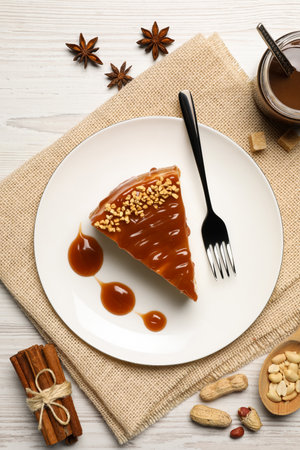 Tasty cheesecake with caramel and nuts served on white wooden table, flat layの写真素材