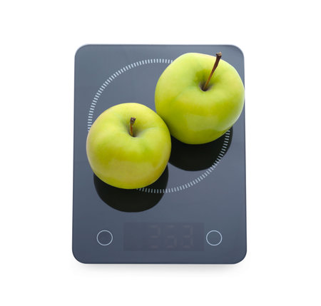 Modern kitchen scale with fresh green apples isolated on whiteの写真素材