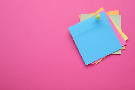 Colorful empty notes pinned on pink background, space for textの写真素材