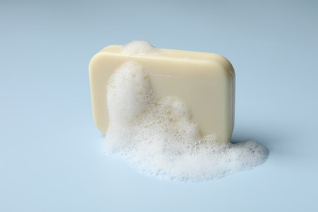 Soap and fluffy foam on light blue backgroundの写真素材