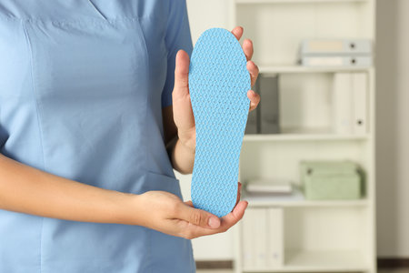 Female orthopedist showing insole in hospital, closeupの写真素材