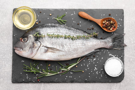 Raw dorado fish and ingredients on light gray table, top view