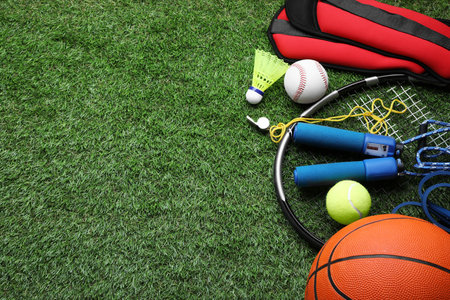 Set of different colorful sports equipment on green grass, above view. Space for textの写真素材