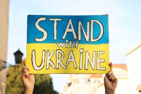 Woman holding poster Stand with Ukraine outdoors, closeupの写真素材