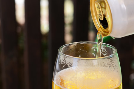Pouring beer from can into glass, closeup. Space for textの写真素材