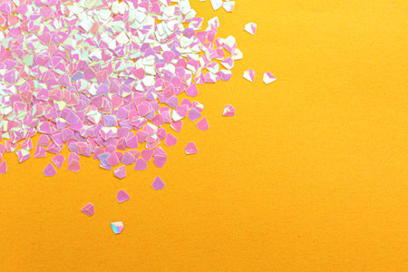 Shiny bright pink glitter on yellow background, flat lay. Space for text