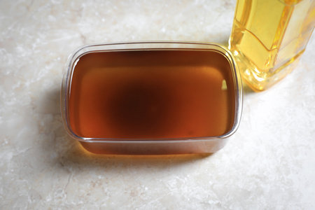 New and used cooking oil on beige marble table, above viewの写真素材