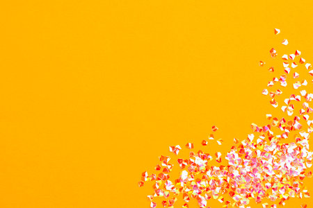 Pile of shiny glitter on orange background, flat lay. Space for textの写真素材