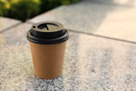 Takeaway paper cup with coffee on stone surface. Space for textの写真素材