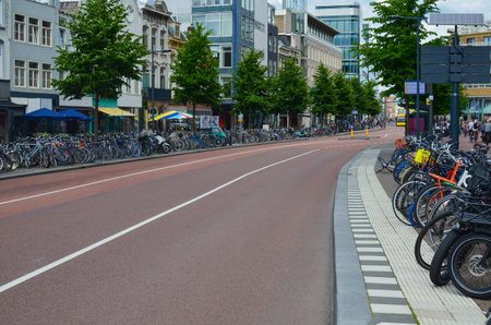 Empty road asphalt and parked bicycles on pavement at cityの写真素材