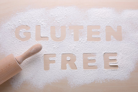Rolling pin and phrase Gluten free written with flour on wooden table, flat layの写真素材