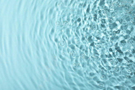 Close up view of water with rippled surface on light blue backgroundの写真素材