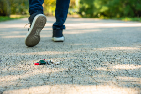 Man walking outside, focus on lost keys. Space for textの写真素材