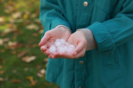 Woman holding hail grains after thunderstorm outdoors, closeupの写真素材